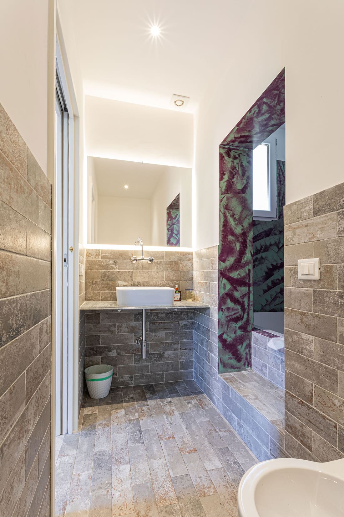 Bagno con lavabo e specchio retroilluminato
